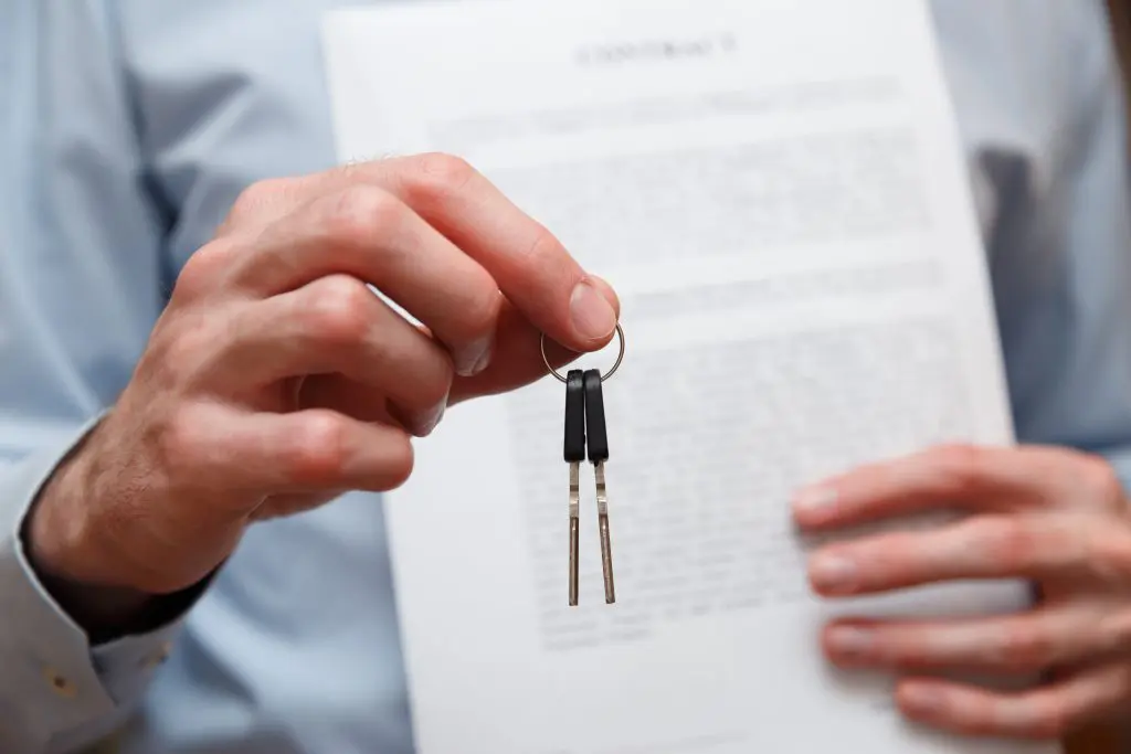 man holding keys and paperwork